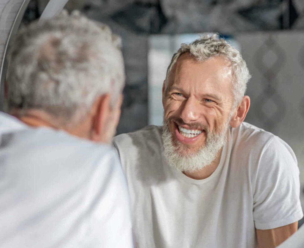 Homme dans un miroir sourire éclatant